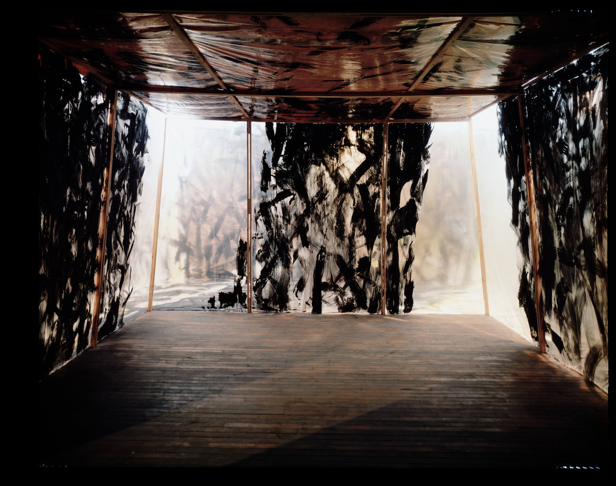 Interior of a room lined with semitransparent painted film over a wood frame, admitting diffuse backlit light.