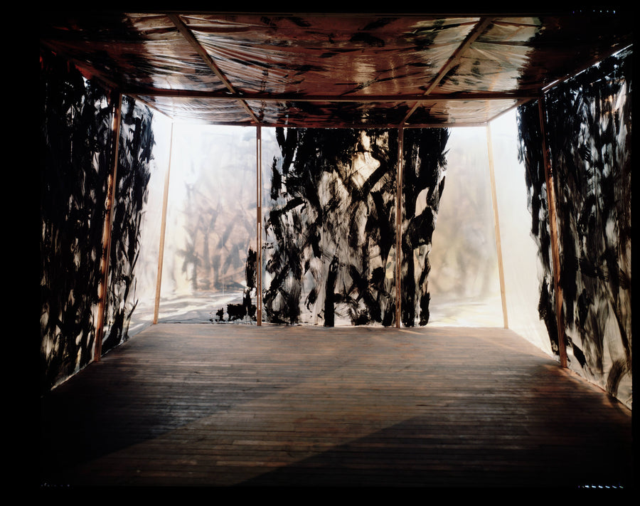 Interior of a room lined with semitransparent painted film over a wood frame, admitting diffuse backlit light.